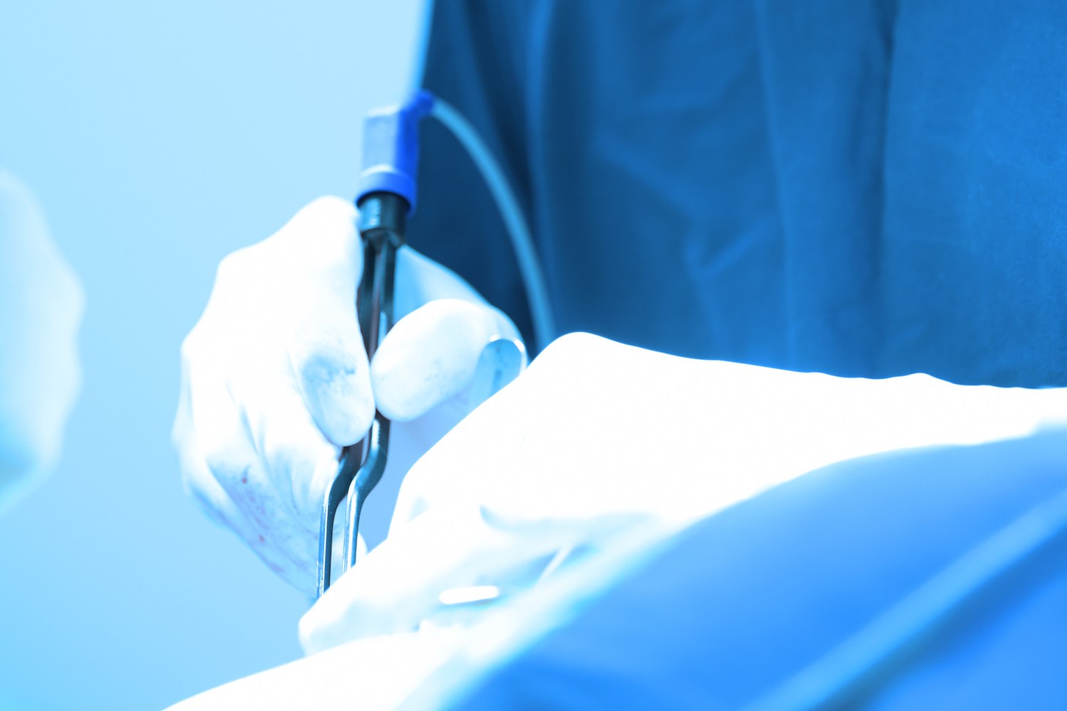 A surgeon's hands using an instrument during surgery